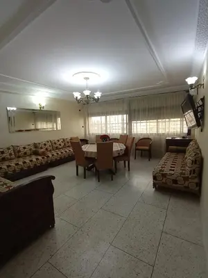 a dining room with a table and chairs and a couch at appartement splendid au centre ville in Fès