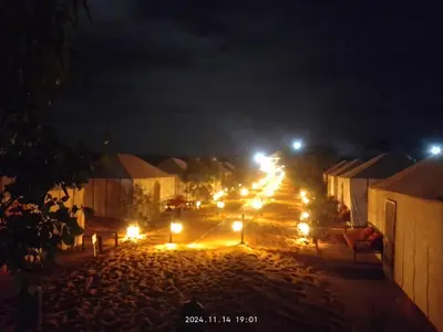a street at night with lights on the road at Moroccco Desert Luxury Tents in Merzouga