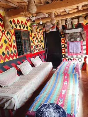 a large bed in a room with a colorful wall at gite Imouzar in Iabassene