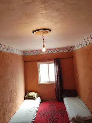 a bedroom with two beds and a window at gite Imouzar in Iabassene