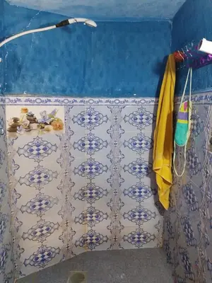 a bathroom with a blue and white tiled wall at gite Imouzar in Iabassene