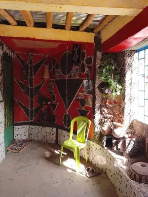 a green chair in a room with a wall at gite Imouzar in Iabassene