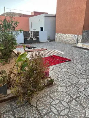 a patio with a tile floor with plants on it at Dar Taznakhte Entre Tapis et Traditions in Tazenakht