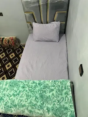 a small bedroom with a bed with a pillow at Dar Taznakhte Entre Tapis et Traditions in Tazenakht