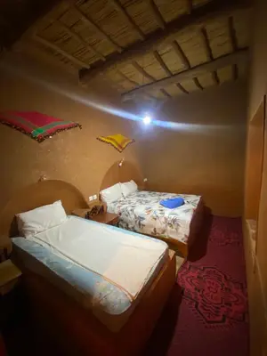 two beds in a small room with two at Auberge camping ouadjou in Nkob