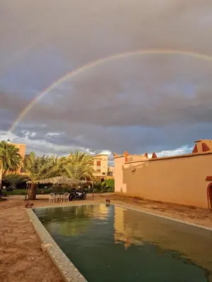 a rainbow over a swimming pool with a pool at Auberge camping ouadjou in Nkob