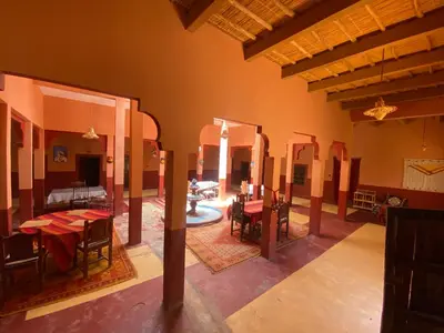 a dining room with tables and chairs in a building at Auberge camping ouadjou in Nkob