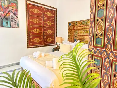 a bedroom with two beds and a plant at Dar Senhaji in Fès