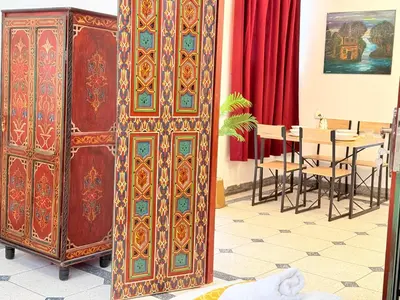 a large wooden cabinet in a room with a table at Dar Senhaji in Fès