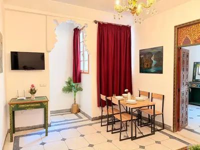 a dining room with red curtains and a table and chairs at Dar Senhaji in Fès