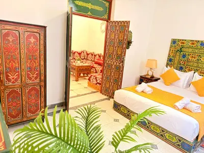 a bedroom with a bed and a chair in a room at Dar Senhaji in Fès