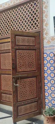 a wooden door with patterns on the side of a building at Dar Tadla Fes in Fès