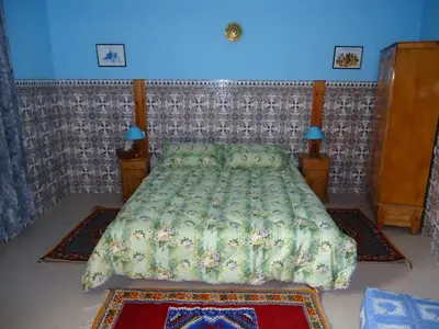 a bedroom with a bed and a blue wall at Dar Tadla Fes in Fès