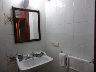 a white bathroom with a sink and a mirror at Dar Tadla Fes in Fès