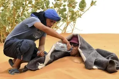 a person playing with a man on the sand at Merzouga activités in Merzouga