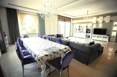 a large living room with a table and a dining room at Splendide Villa 5 chambres de luxe PRIVATISEE avec Cuisinière - Piscine chauffée - Jacuzzi & Hammam in Had Abdallah Rhiat