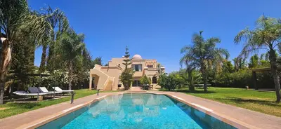 a villa with a swimming pool in front of a house at Splendide Villa 5 chambres de luxe PRIVATISEE avec Cuisinière - Piscine chauffée - Jacuzzi & Hammam in Had Abdallah Rhiat