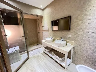 a bathroom with two sinks and a shower at Splendide Villa 5 chambres de luxe PRIVATISEE avec Cuisinière - Piscine chauffée - Jacuzzi & Hammam in Had Abdallah Rhiat