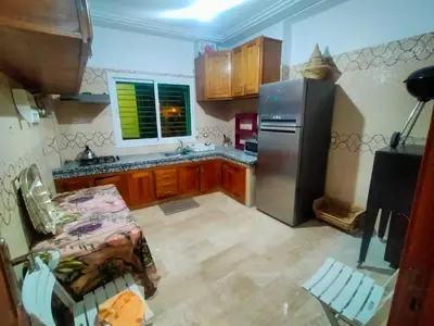 a kitchen with a stainless steel refrigerator and wooden cabinets at Célia House in Fès