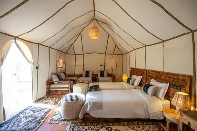 a bedroom with four beds in a tent at Morocco Tours Camp in Merzouga