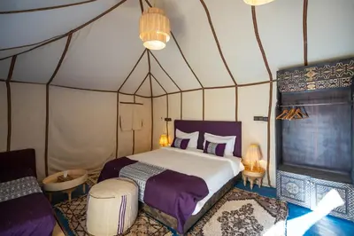 a bedroom with a bed in a tent at Morocco Tours Camp in Merzouga