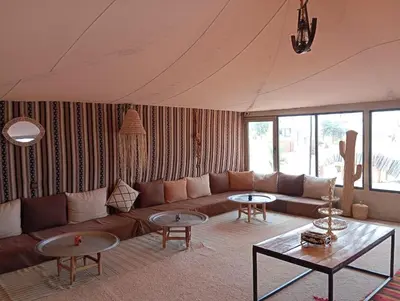 a living room with a couch and two tables at Kalimba Luxury Desert Camp in Merzouga
