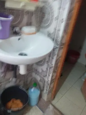 a bathroom with a sink and a trash can at Chez l'habitant Fatima in Arhbar
