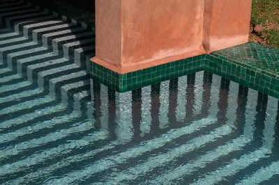 a pool of water next to a column with green tiles at Luxurious Villa with private pool - Kasbah Conti in Marrakech