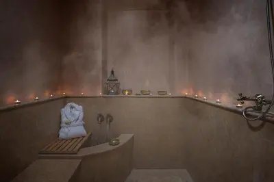 a bathroom with a bathtub with a statue and candles at Luxurious Villa with private pool - Kasbah Conti in Marrakech