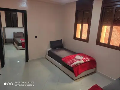 a small bed in a room with a red blanket at hotel DIJON ouzoud in Ouzoud