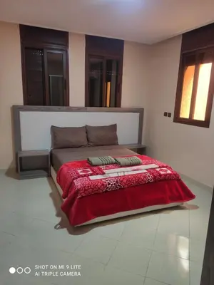 a bedroom with a bed with a red blanket at hotel DIJON ouzoud in Ouzoud