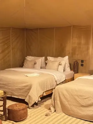 a room with two beds in a tent at Desert Camp in Merzouga