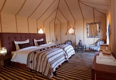 a bedroom with two beds in a tent at Desert Camp in Merzouga