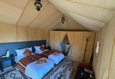 a bedroom with two beds in a tent at Desert Camp in Merzouga