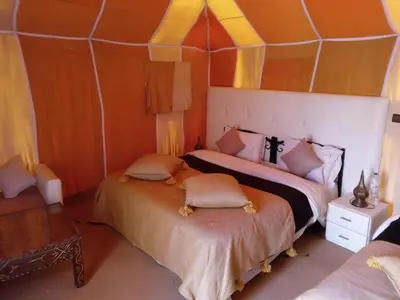a bedroom with two beds in a tent at Amidinine Desert Camp in Merzouga