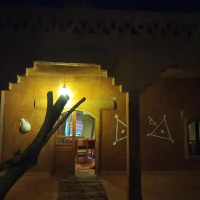 a street light in front of a building at night at Auberge Itrane merzouga in Merzane