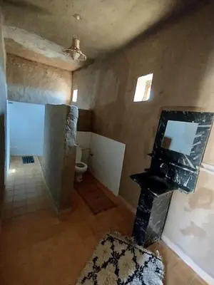 a bathroom with a toilet and a mirror at Auberge Itrane merzouga in Merzane