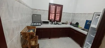a small kitchen with a sink and a refrigerator at Appartement familial confortable au centre ville in El Kelaa des Srarhna
