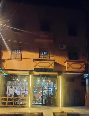 a building with a restaurant with tables and chairs at Appartement familial confortable au centre ville in El Kelaa des Srarhna