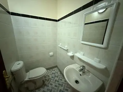 a bathroom with a toilet and a sink and a mirror at Appartement familial confortable au centre ville in El Kelaa des Srarhna