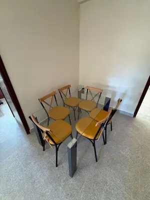 a group of chairs and a table in a room at Appartement familial confortable au centre ville in El Kelaa des Srarhna