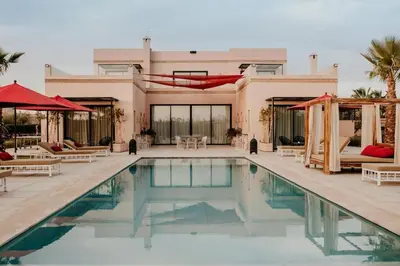 a swimming pool in front of a house at Luxury 5-Suite Villa with Heated Pool, Steam Room & Games in Marrakech