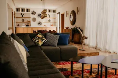 a living room with a couch and a table at Luxury 5-Suite Villa with Heated Pool, Steam Room & Games in Marrakech