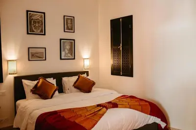 a bedroom with a bed with orange pillows at Luxury 5-Suite Villa with Heated Pool, Steam Room & Games in Marrakech