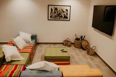 a living room with couches and a flat screen tv at Luxury 5-Suite Villa with Heated Pool, Steam Room & Games in Marrakech