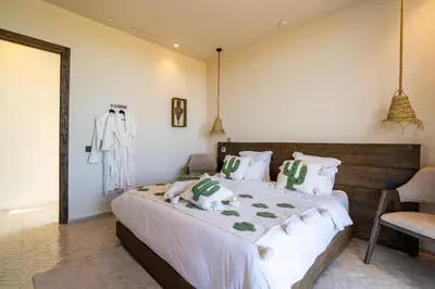 a bedroom with a large bed with white and green pillows at VILLA 2s in Marrakech