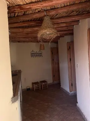 a living room with a wooden ceiling and a table at Moroccan Desert Camp in Merzouga