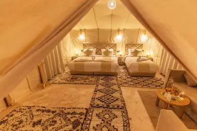 two beds in a room with a staircase at Amodo desert camp in Merzouga
