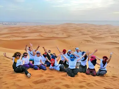 a group of people sitting in the desert at Amodo desert camp in Merzouga