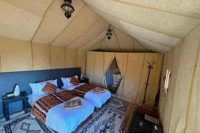 a bedroom with two beds in a tent at Amodo desert camp in Merzouga